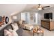 A cozy bonus room features comfortable seating, a ceiling fan, and stylish decor at 478 Rowley Ln, Summerville, SC 29486