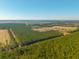 The property is surrounded by dense trees and is located near a quiet road. A future development is underway nearby at 516 & 508 Robnshers Pl, Ridgeville, SC 29472