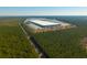 A large industrial building with a long parking lot surrounded by lots of green trees at 516 & 508 Robnshers Pl, Ridgeville, SC 29472