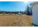 Vast back yard with a shed and carport near the treeline in the distance on a bright sunny day at 516 & 508 Robnshers Pl, Ridgeville, SC 29472