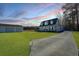 Charming home with a long driveway, a lush green lawn, and a detached garage under a colorful sunset sky at 516 & 508 Robnshers Pl, Ridgeville, SC 29472