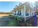 Inviting wraparound porch featuring classic rocking chairs, white columns, and lush landscaping around the perimeter at 516 & 508 Robnshers Pl, Ridgeville, SC 29472