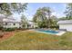 Serene backyard with a swimming pool, lush lawn, and mature trees for outdoor enjoyment at 521 London Bridge Rd, Mount Pleasant, SC 29464