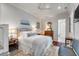 A serene main bedroom featuring wood floors, a plush bed, and a glimpse into the ensuite bathroom at 521 London Bridge Rd, Mount Pleasant, SC 29464