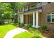 Charming front porch with brick steps and mature plantings, leading to a gray front door with sidelights at 652 E Hobcaw Dr, Mount Pleasant, SC 29464