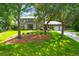 Traditional brick home with a well-manicured lawn, mature trees, and a welcoming entrance at 652 E Hobcaw Dr, Mount Pleasant, SC 29464
