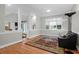 Bright living room with hardwood floors, neutral walls, and a comfortable black leather sofa at 652 E Hobcaw Dr, Mount Pleasant, SC 29464