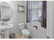 Cozy half bathroom features pedestal sink, round mirror, and a storage shelf at 7806 Park Gate Dr, North Charleston, SC 29418