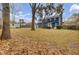 Large backyard featuring a lush lawn, mature trees, and a charming blue house with a patio at 102 Eastover Cir, Summerville, SC 29483