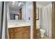 Traditional bathroom featuring a wood vanity, framed mirror, and adjacent toilet with window at 102 Eastover Cir, Summerville, SC 29483