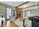 Cozy living room with a brick fireplace, exposed beams, and built-in bookshelves at 102 Eastover Cir, Summerville, SC 29483