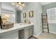 Well-lit bathroom with a spacious vanity, framed mirror, and decorative ladder at 1052 Whitlow Blvd, Summerville, SC 29483