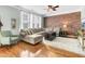 Bright living room with a brick accent wall, ample seating, and large windows for natural light at 1052 Whitlow Blvd, Summerville, SC 29483
