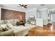 Cozy living room with exposed brick wall, comfortable seating, wood floors, and a ceiling fan at 1052 Whitlow Blvd, Summerville, SC 29483