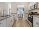 A modern kitchen features stainless steel appliances, granite countertops and white cabinetry at 111 O'Leary Circle, Summerville, SC 29483