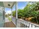 Balcony with wood floor and white railings offering scenic neighborhood views filled with lush greenery at 112 E Huron Ave # C, Folly Beach, SC 29439