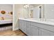 Bathroom showcasing a double vanity with gray cabinets and view of the guest bedroom at 112 E Huron Ave # C, Folly Beach, SC 29439
