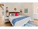 Charming bedroom features a queen bed with white comforter and blue accents, with wood floors at 112 E Huron Ave # C, Folly Beach, SC 29439