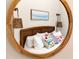 Cozy bedroom reflected in a round mirror, featuring a comfortable bed and stylish décor at 112 E Huron Ave # C, Folly Beach, SC 29439