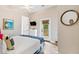 Cozy bedroom with white and blue bedding, complemented by a round mirror and a door to a small balcony at 112 E Huron Ave # C, Folly Beach, SC 29439
