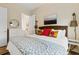 Bedroom with a woven headboard, colorful throw pillows, and access to an ensuite bathroom at 112 E Huron Ave # C, Folly Beach, SC 29439