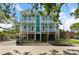 Charming two-story home with dual balconies, set against a backdrop of lush greenery and blue skies at 112 E Huron Ave # C, Folly Beach, SC 29439