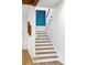 Bright stairway with wood treads and white risers, accented by a blue art piece and modern lighting at 112 E Huron Ave # C, Folly Beach, SC 29439
