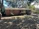 View of the brick home, featuring a walkway to the front door, and an overgrown yard with lots of mature foliage at 1146 Brigantine Dr, Charleston, SC 29412