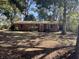 Cozy single story brick home featuring red shutters surrounded by large shady trees in the front yard at 1146 Brigantine Dr, Charleston, SC 29412