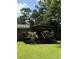 View of the backyard featuring a brick home and a wood deck, with stairs leading to the green yard at 125 Azalea Dr, Summerville, SC 29485