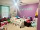 A bedroom with purple walls includes decor items and a comfy bed at 1915 Sweetfern Rd, Hanahan, SC 29410