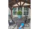 Outdoor dining area beneath a pergola, featuring a round table, swivel chairs, and potted ferns at 1915 Sweetfern Rd, Hanahan, SC 29410