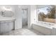 Bright bathroom with a window view, white cabinets, and bathtub with jets at 193 Shadowmoss Pkwy, Charleston, SC 29414