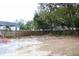 A backyard with a mix of gravel and dirt areas, surrounded by trees and a wooden fence at 2008 Cosgrove Ave, North Charleston, SC 29405