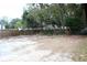 A backyard with a mix of gravel and dirt areas, surrounded by trees and a wooden fence at 2008 Cosgrove Ave, North Charleston, SC 29405