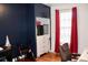 Bright bedroom features hardwood floors, a closet, window with red curtains, desk, and accessible mobility aid at 2008 Cosgrove Ave, North Charleston, SC 29405