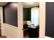 A view into an office with a dark accent wall and a desk in front of a window at 2008 Cosgrove Ave, North Charleston, SC 29405