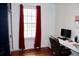 Office space with bright light with a modern desk and red curtains by the window at 2008 Cosgrove Ave, North Charleston, SC 29405