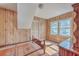 Bedroom featuring wood paneled walls, hardwood floors, and natural light from two windows at 2181 Edisto Ave, Charleston, SC 29412