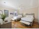 Bright bedroom with two beds features hardwood floors, ceiling fan, and two windows at 249 Ashley Ave, Charleston, SC 29403