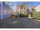 Charming two-story home with a gravel driveway, beautiful paint, and a vibrant turquoise front door at 249 Ashley Ave, Charleston, SC 29403