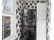 Laundry room featuring new stacked washer and dryer unit with custom wallpaper and cabinets at 249 Ashley Ave, Charleston, SC 29403