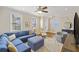 Well-lit living room with a stylish blue sectional sofa, and a view into the foyer and dining area at 249 Ashley Ave, Charleston, SC 29403