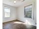 Bedroom featuring two windows, neutral walls, stylish wood-look flooring, and electrical outlets at 2694 Olympia Ave, North Charleston, SC 29405