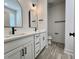 Modern bathroom featuring dual sinks, a white vanity, black hardware, and a tiled floor at 3004 Harvey Ave, North Charleston, SC 29405