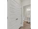 Hallway view to the bathroom showing white doors and trim, with wood-look floors at 304 O'Malley Dr, Summerville, SC 29483