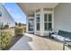 Inviting front porch featuring a seating area with bench and an entry with decorative shuttered windows at 313 Bloomington Way, Summerville, SC 29486