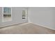 An empty bedroom features neutral carpet, two windows that offer natural light, and freshly painted walls at 324 Abercom Place Dr, Moncks Corner, SC 29461