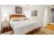 Warm bedroom showcasing a wooden bed frame, patterned rug, and a scenic painting at 32-E Prioleau St, Charleston, SC 29401