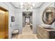 Elegant foyer with a modern chandelier, elevator, and a decorative mirror above a wooden chest of drawers at 32-E Prioleau St, Charleston, SC 29401